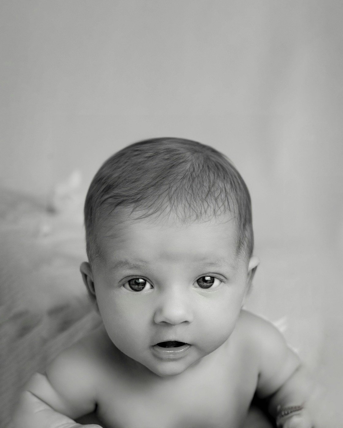 Black-and-white portrait of an alert baby looking towards the camera
